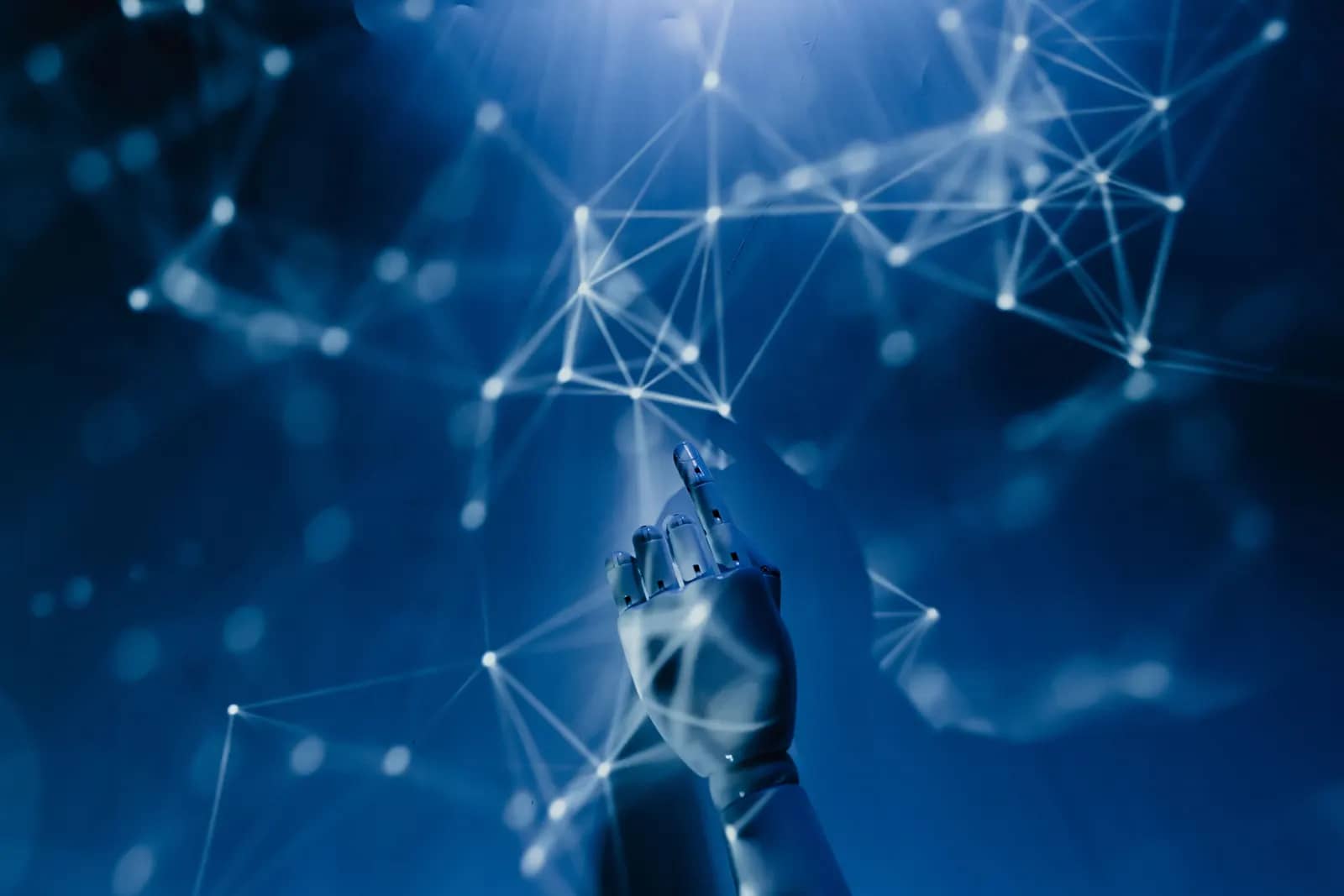 A robotic hand reaching up into a glowing network of connected points.