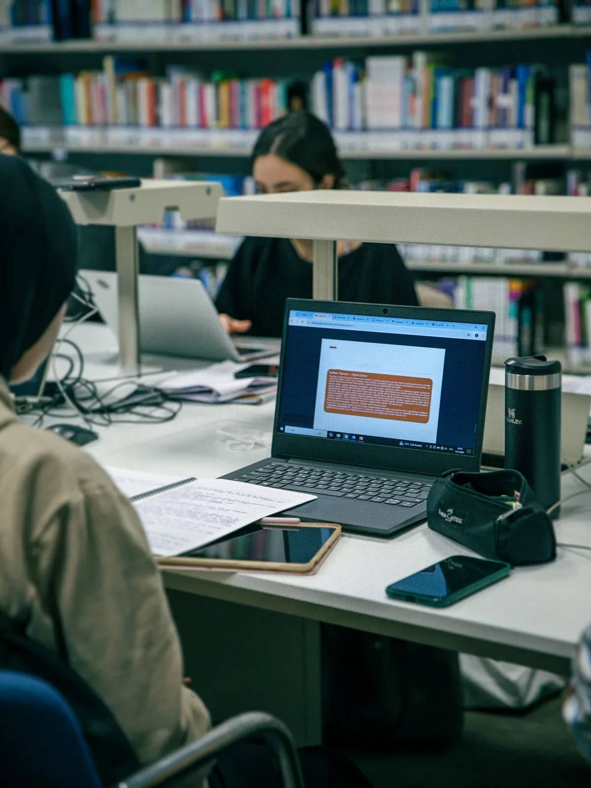 Students working on laptops in a university library
