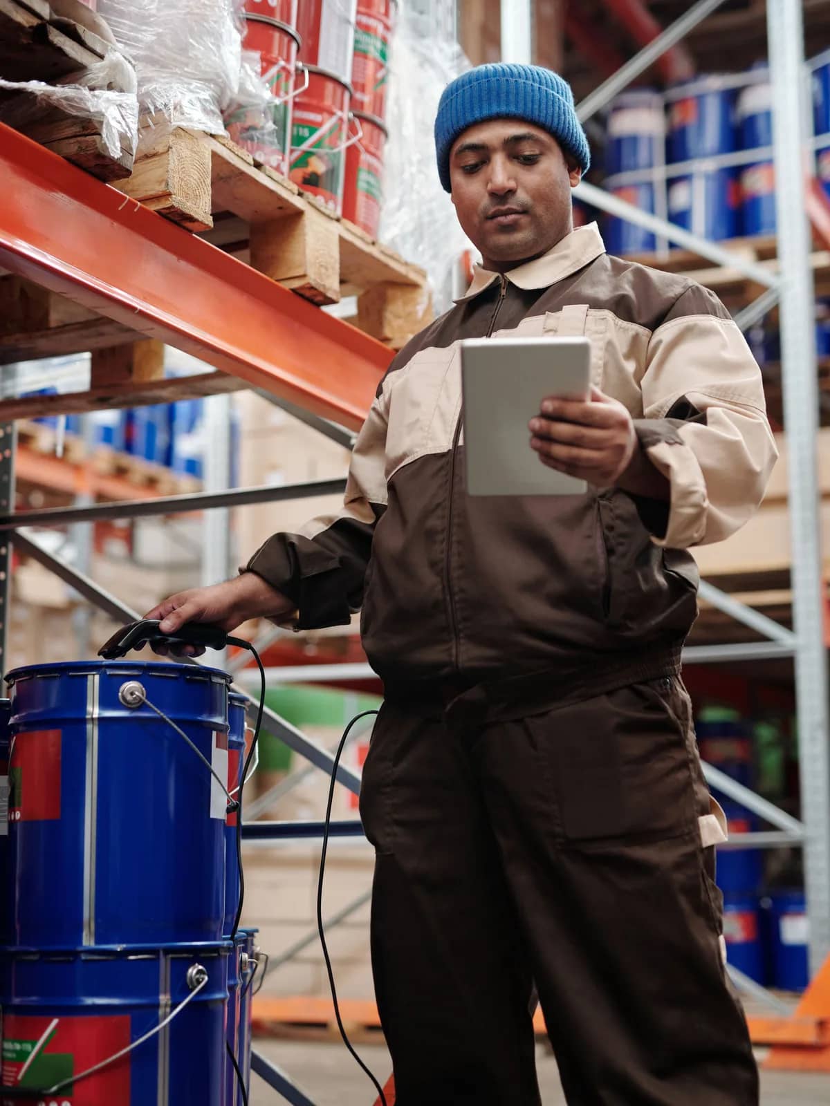 Warehouse operator checking stock on a tablet among racking