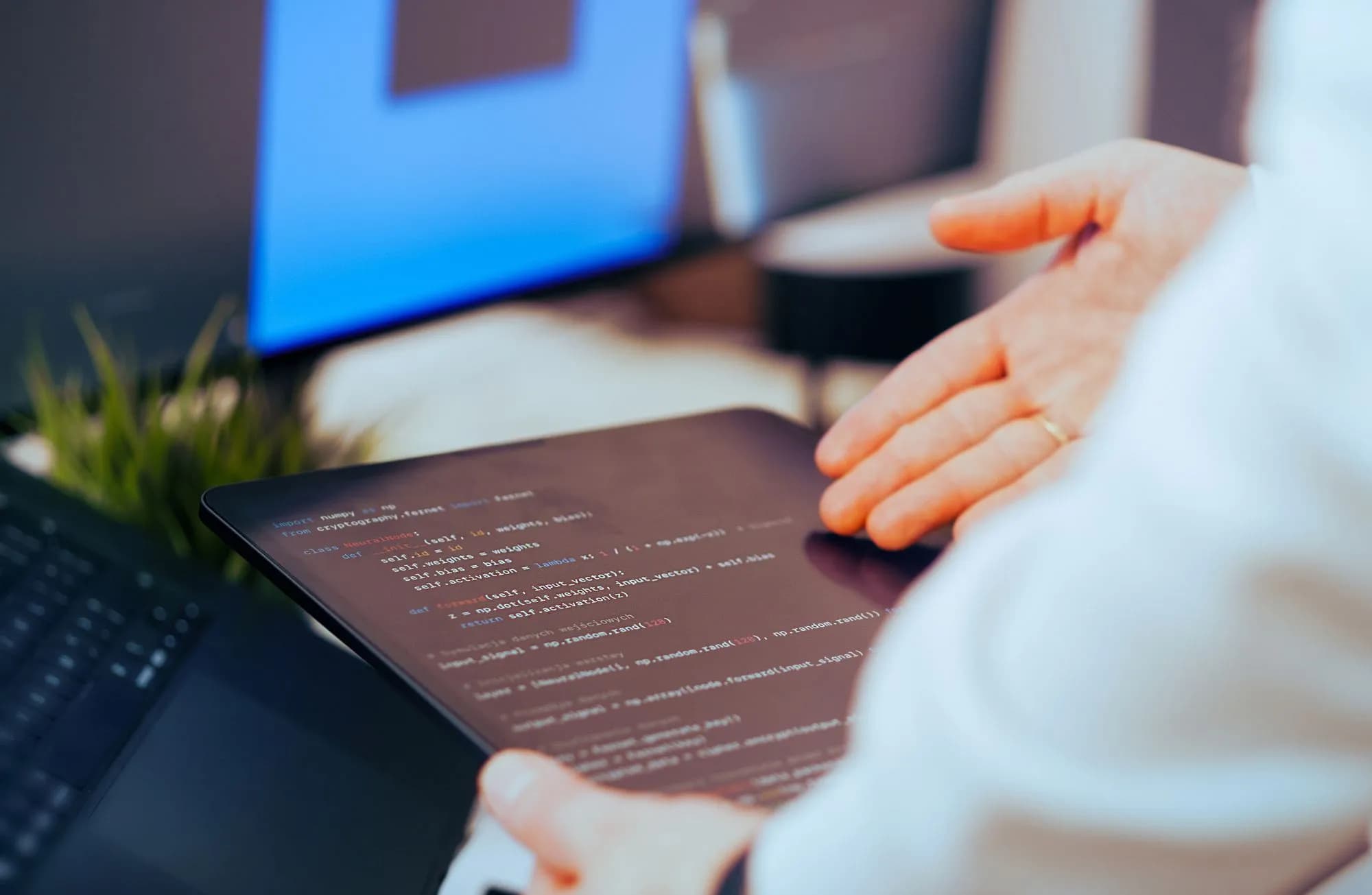 Software developer reviewing code on a tablet in an office